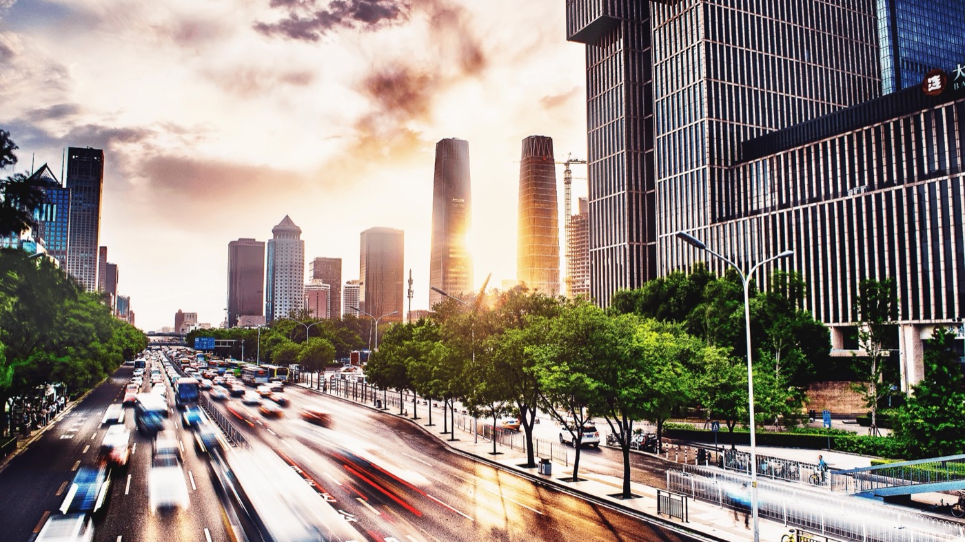 Busy city avenue with moving traffic and high-rise buildings